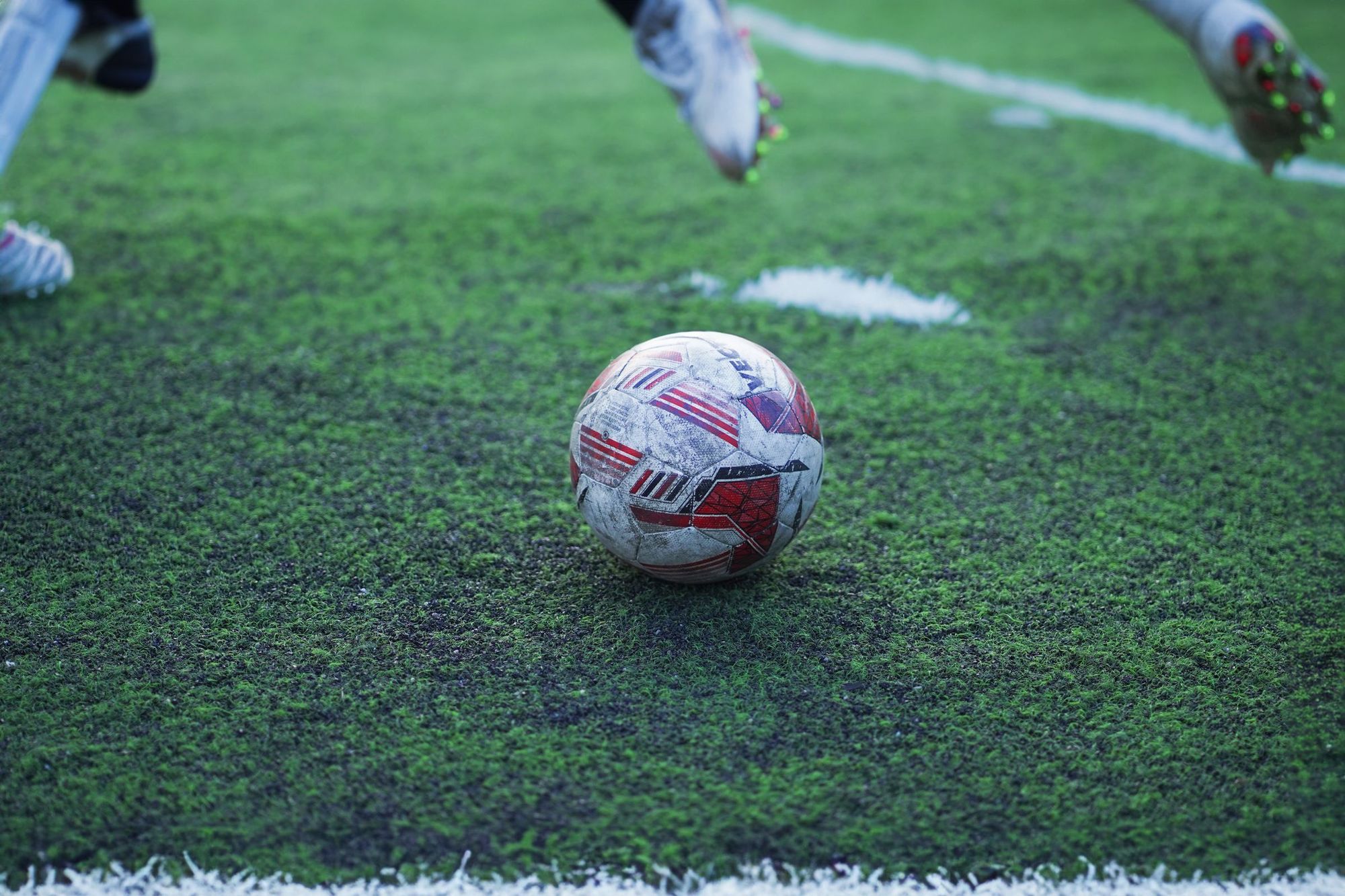 A football on a wet grass pitch during play