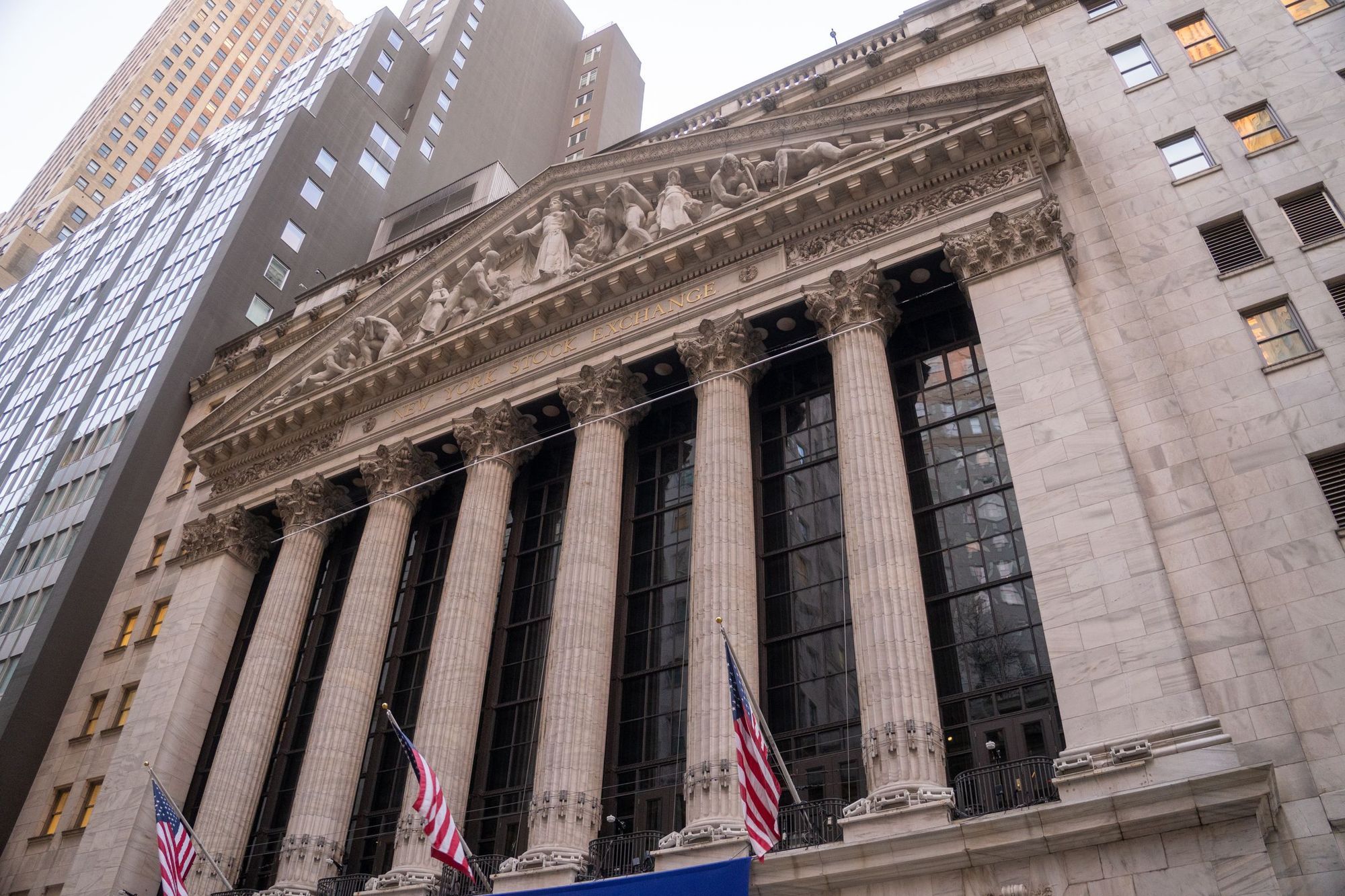 The columned facade of the New York Stock Exchange with American flags